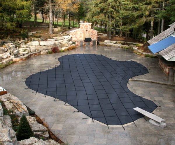 Underground pool covered by blue safety cover in Winter
