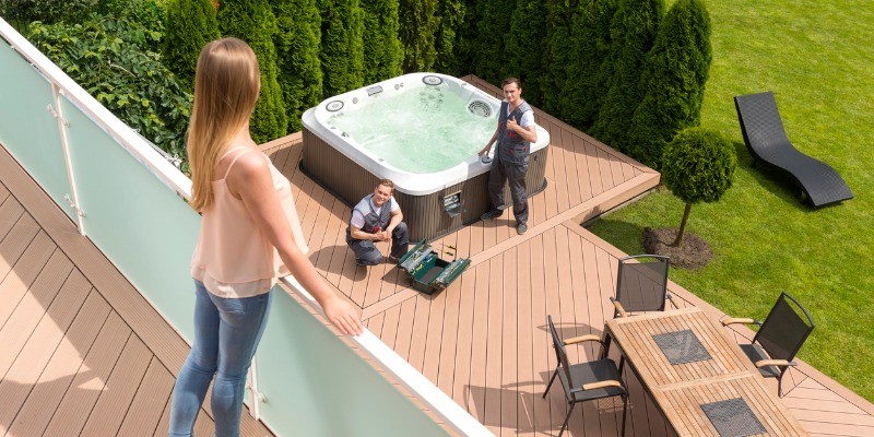 Lady looking over balcony to hot tub installers