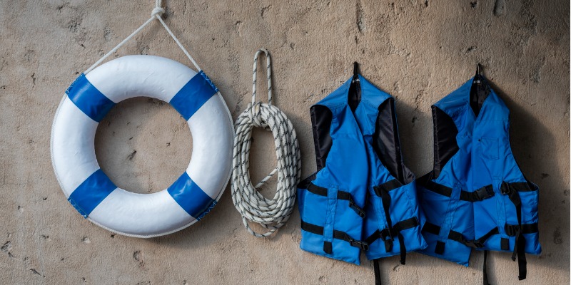 Life jacket, rope and life saving floaty on wall