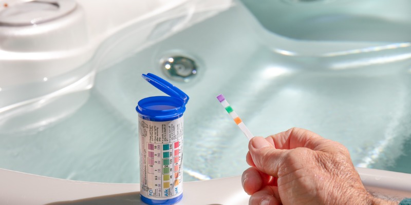 Person testing hot tub water with ph strip