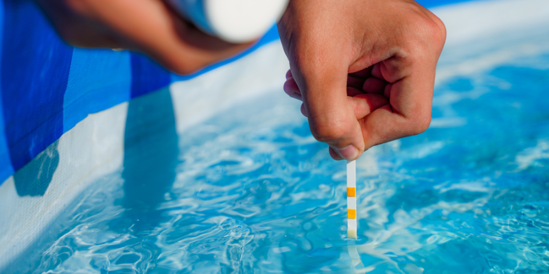 Person testing pH balance in pool - The Importance of Balancing Your Pool's pH Level 