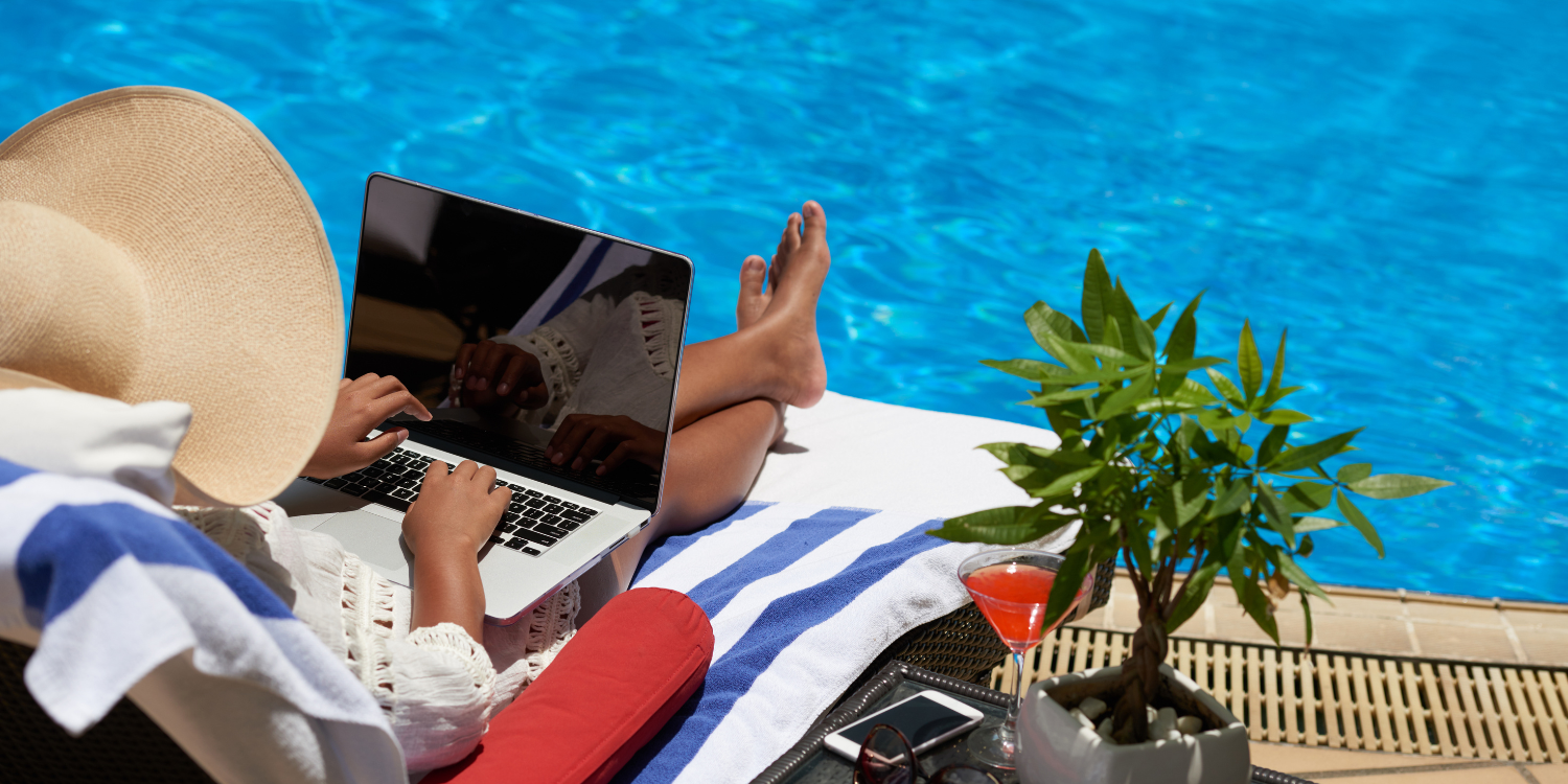 Sitting by pool and working on laptop - Boost Productivity, Lower Stress & More: 5 Benefits of Working by the Pool 