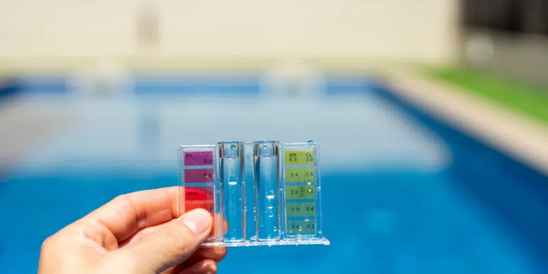 Testing swimming pool water chemistry using a liquid reagent test comparator block.
